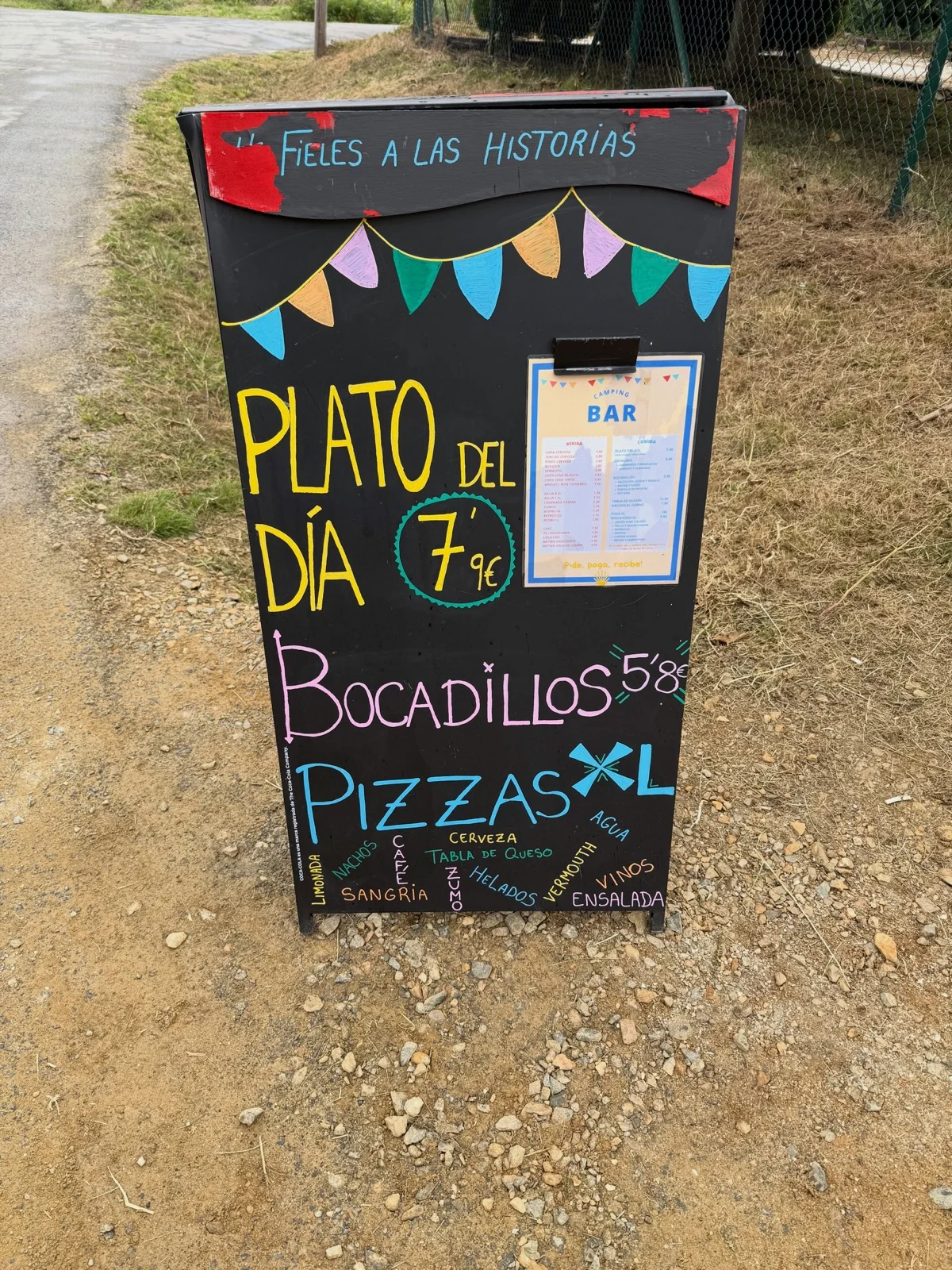 路邊黑板寫著 Plato del día、Bocadillos 和 Pizzas XL