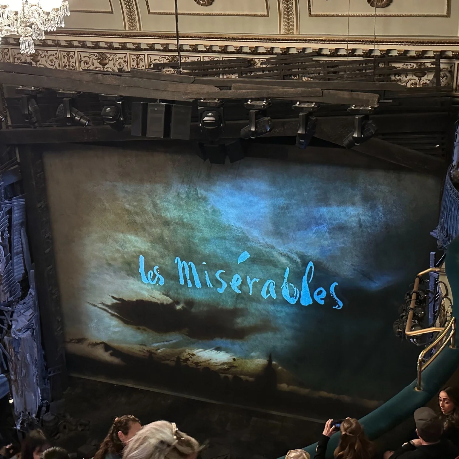 《悲慘世界》開演前，舞台布幕上投影著藍色的 Les Misérables 字樣
