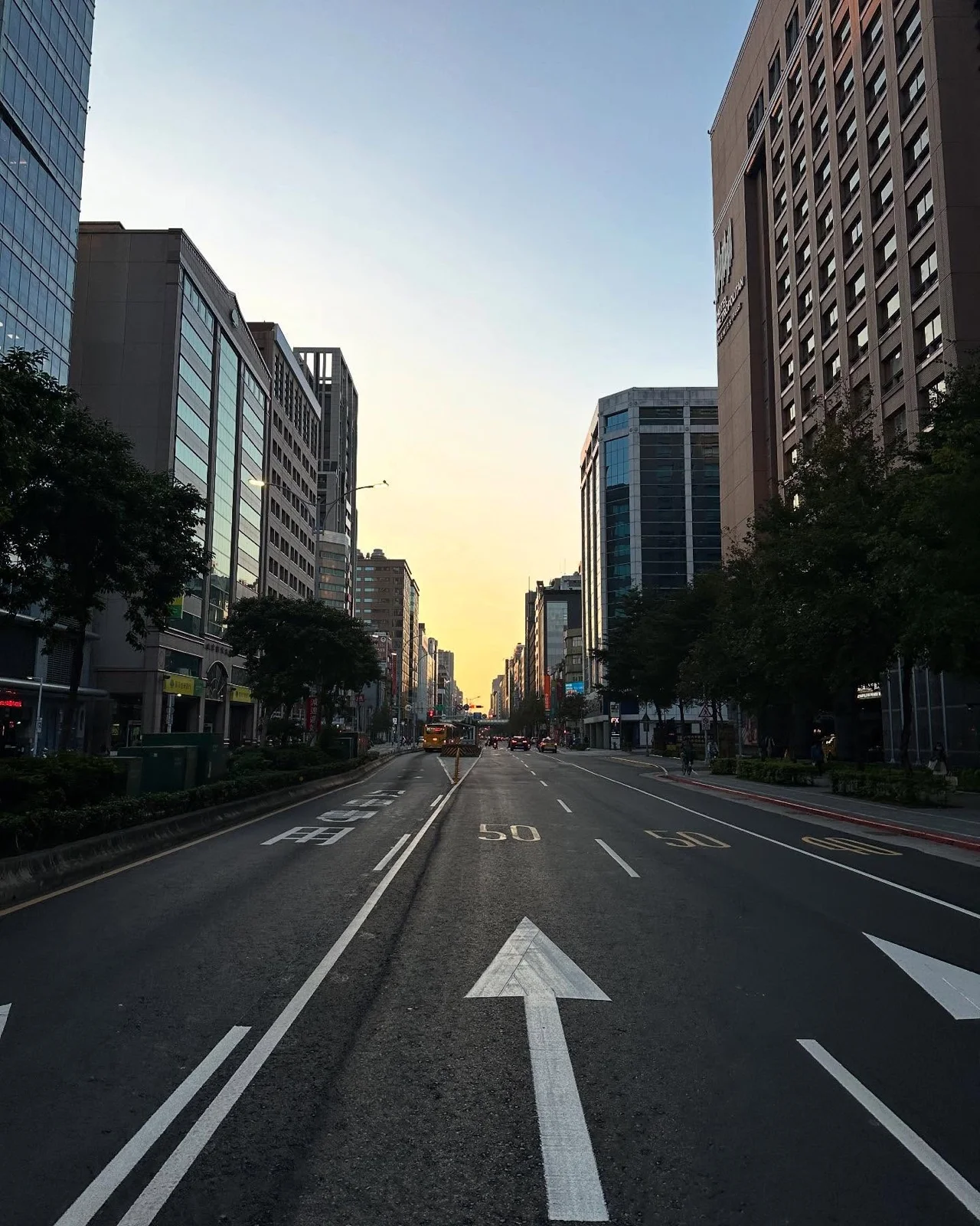 清晨空蕩的大馬路,地上的白色箭頭指向遠方的日出