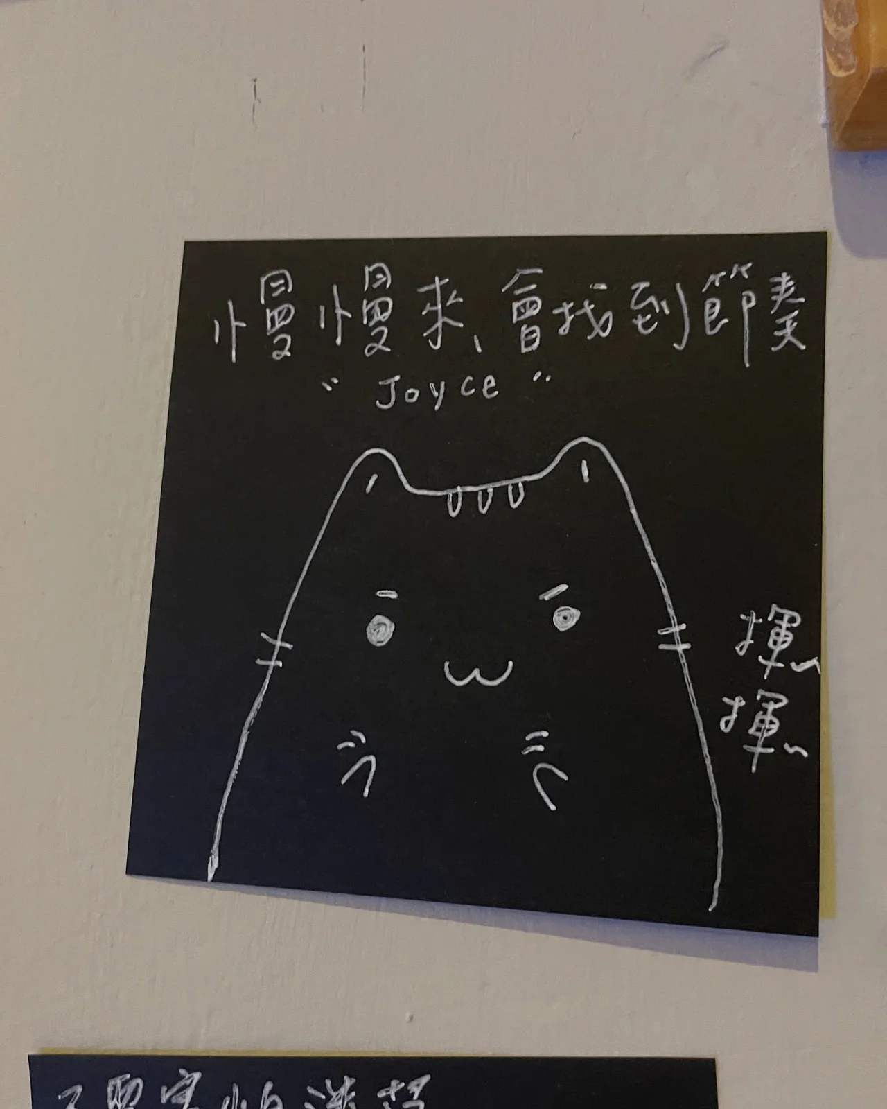黑色便利貼上的手寫字：「慢慢來，會找到節奏」，旁邊畫了一隻貓